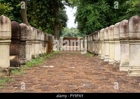 Allée pavée en pierre de latérite avec des postes en pierre aux portes de l'ancien temple Khmer Prasat Sdok Kok Thom dans Sa Kaeo province de Thaïlande Banque D'Images