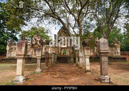 Allée pavée en pierre de latérite avec des postes en pierre aux portes de l'ancienne 11ème siècle temple khmer Prasat Sdok Kok Thom dans Sa Kaeo province de Thaïlande Banque D'Images