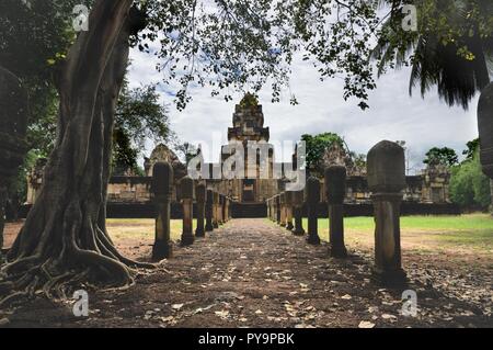 Allée pavée en pierre de latérite avec des postes à la cour en pierre portes de l'ancien temple Khmer Prasat Sdok Kok Thom dans Sa Kaeo province de Thaïlande Banque D'Images