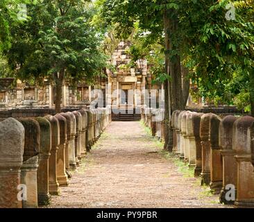 Allée pavée en pierre de latérite avec des postes en pierre aux portes de l'ancienne 11ème siècle temple khmer Prasat Sdok Kok Thom dans Sa Kaeo province de Thaïlande Banque D'Images