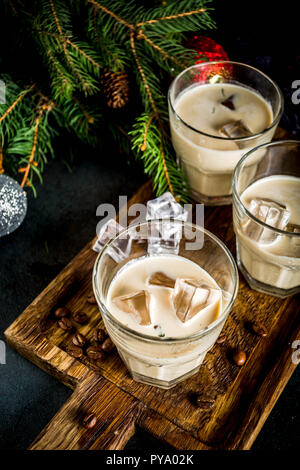 Irish Cream Liqueur cocktail ou boisson traditionnelle de Noël, d'hiver, avec l'arrière-plan foncé rusty branches de sapins de Noël, les grains de café et decorati Banque D'Images