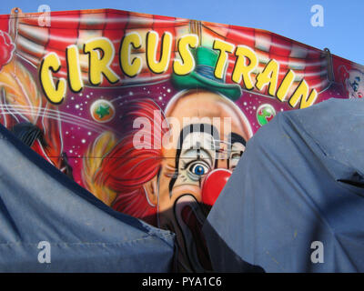 Le visage heureux d'un clown peint à l'extérieur d'un parcours de parc d'expositions - train de cirque. Écosse Banque D'Images