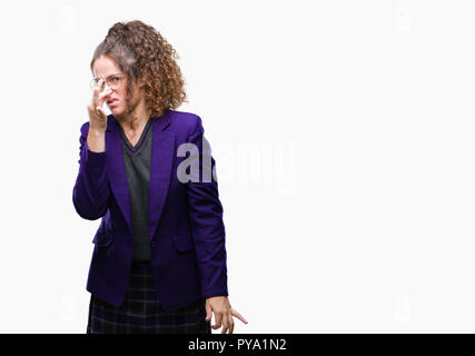 Jeune étudiante brunette girl wearing school uniform et verres sur fond isolé humer un stinky et dégoûtant, odeur insupportable, h Banque D'Images