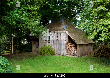 Jardiniers en bois ancien hangar avec log storage en jardin anglais,Angleterre,Europe Banque D'Images