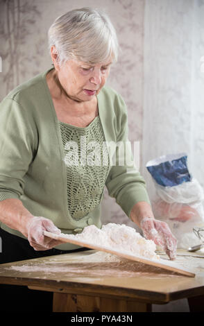 Une vieille dame faisant peu de tartes. Pétrir la pâte. Portrait Banque D'Images