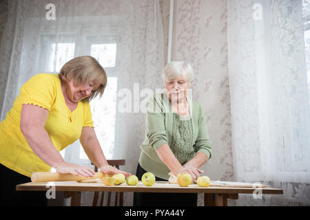 Deux personnes âgées femme faisant peu de tartes. Pétrir la pâte. Banque D'Images