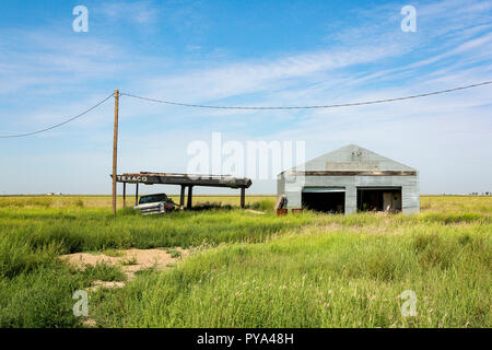 Texaco déserte garage et station service à Poile, Texas, USA. Végétation et abandonné. Voiture abandonnée Banque D'Images