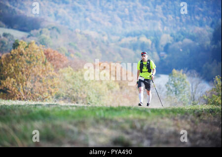 République tchèque, SLAPY, Octobre 2018 : Trail Maniacs Exécuter la concurrence. Homme barbu avec l'exécution de bâtons sur pré. Atmosphère d'automne. Banque D'Images