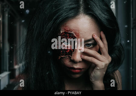 Close-up portrait of a zombie effrayant horrible femme avec des yeux d'horreur sanglante, maquillage d'Halloween. Banque D'Images