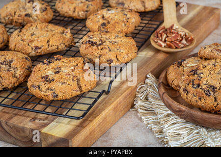 Biscuits aux noix et raisins sur une grille de refroidissement avec une cuillerée de noix et la plaque de cookies Banque D'Images