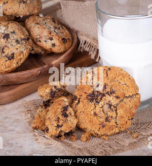 Biscuits à la noix et raisins et verre de lait avec la plaque de cookies en arrière-plan Banque D'Images