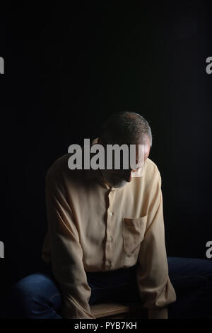 Homme assis avec sa tête vers le bas 29/5000 triste homme d'âge moyen Banque D'Images