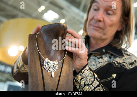 Munich, Allemagne. 26Th Oct, 2018. 26 octobre 2018, Allemagne, Munich : Designer Jo Wilitzky attache un collier pour une présentation sur la plaque en bois le jour de l'ouverture de 'Mineralientage' trade fair. Credit : Tobias Hase/dpa/Alamy Live News Banque D'Images