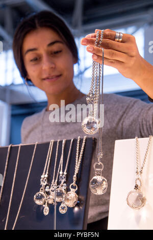 Munich, Allemagne. 26Th Oct, 2018. 26 octobre 2018, Allemagne, Munich : le jour de l'ouverture de la foire commerciale ineralientage «', un employé détient les chaînes à l'ensemble des boules de cristal dans ses mains. Credit : Tobias Hase/dpa/Alamy Live News Banque D'Images