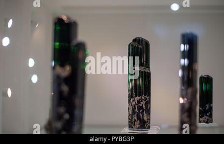 Munich, Allemagne. 26Th Oct, 2018. 26 octobre 2018, Allemagne, Munich : Diverses tourmalines brillant vert sont allumés dans une vitrine sur le minéral jours. Le Minéral jours sont une foire de vente de Minéraux, Fossiles et Gemmes qui continue jusqu'au 28 octobre. Credit : Lino Mirgeler/dpa/Alamy Live News Banque D'Images