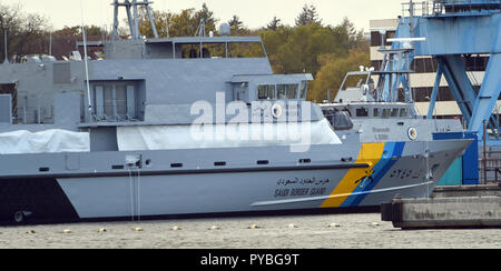 Wolgast, Allemagne. 25 octobre, 2018. 25 octobre 2018, l'Allemagne, Wolgast : un navire militaire (un navire de type inconnu) et une protection des côtes bateau (arrière-plan) pour l'Arabie Saoudite sont couchées à l'équipement quai du chantier naval Peene. Le Bremen Luerssen Groupe, auquel l'Wolgaster shipyard appartient, avait reçu les milliards de contrat pour la construction d'une flotte de nouveaux navires de patrouille de l'Arabie et commencé la construction en 2015. Credit : Stefan Sauer/dpa-Zentralbild/ZB/dpa/Alamy Live News Banque D'Images