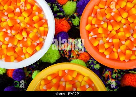 Blanc, orange et jaune avec des plaques de maïs bonbons et boules de fils sous les plaques de ci-dessous en vert, orange, violet et noir. Halloween fête par Banque D'Images