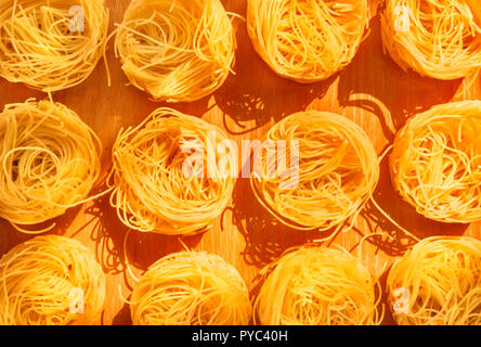 Beaux nids de pâtes cheveux d'ange était sur une planche en bois ,pâtes douces ombres sur le conseil ,Vue de dessus ,ces rubans minces de pâtes sont également appelés Banque D'Images