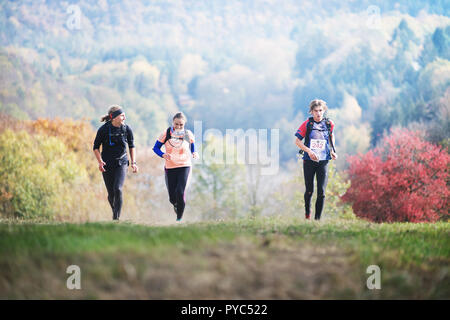 République tchèque, SLAPY, Octobre 2018 : Trail Maniacs Exécuter. Homme Competite avec jeune couple. Forêt d'automne sur l'arrière-plan. Banque D'Images