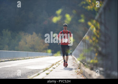 République tchèque, SLAPY, Octobre 2018 : Trail Maniacs Exécuter la concurrence. Homme qui court à travers le pont. Faible profondeur de champ et le rétroéclairage. Banque D'Images