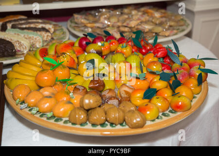 Petite Amande bonbons en forme de fruits disposées sur une plaque ronde. Banque D'Images