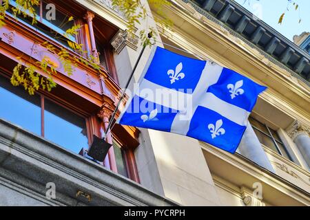 Un drapeau du Québec avec lys blanc fleurs flottant sur la rue à Montréal, Canada Banque D'Images