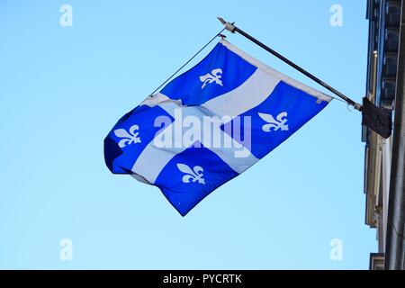 Un drapeau du Québec avec lys blanc fleurs flottant sur la rue à Montréal, Canada Banque D'Images