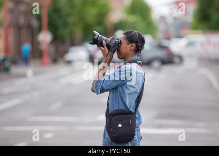 Portland, OR / USA - 11 juin 2016 : Grand défilé floral, African American female photographe prendre des photos avec votre appareil photo reflex numérique Canon. Banque D'Images