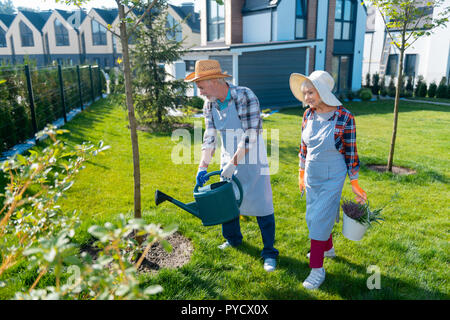 Joli gentil couple l'arrosage des plantes ensemble dans le jardin Banque D'Images