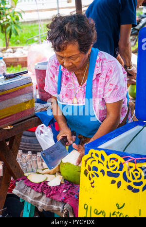 Amphawa, Thaïlande - Sept 13, 2015 : couper une noix de coco fraîche au marché alimentaire. Banque D'Images