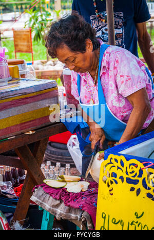 Amphawa, Thaïlande - Sept 13, 2015 : couper une noix de coco fraîche au marché alimentaire. Banque D'Images