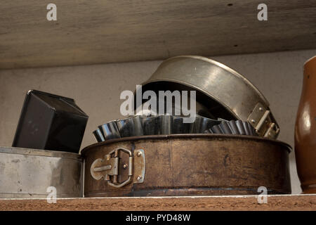 Vieux moules de cuisson sur une vieille table de cuisine. Accessoires de cuisson dans la cuisine. table en bois. Banque D'Images