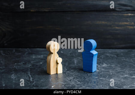 Figurines en bois de la mère à l'enfant et le père. Le concept d'une famille solide, le favoritisme. Trouver un nouveau père pour un enfant. La déchéance de l'autorité parentale Banque D'Images