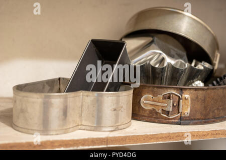 Vieux moules de cuisson sur une vieille table de cuisine. Accessoires de cuisson dans la cuisine. table en bois. Banque D'Images