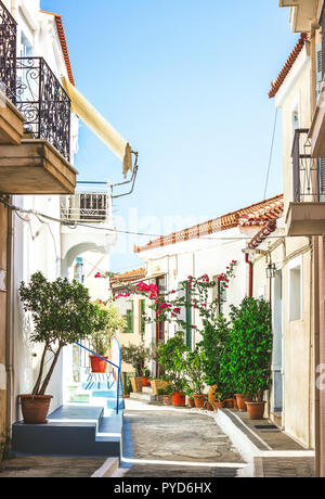 Rues étroites de la ville dans l'île de Poros Neorio, Grèce ; vieux maisons blanches avec des fleurs Banque D'Images