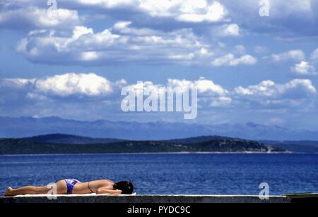 Woman wall le bain de soleil,Dugi Otok, Croatie | Le monde d'utilisation Banque D'Images