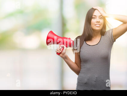 Young hispanic woman pointing a souligné avec la main sur la tête, choqué par la honte et la surprise face, en colère et frustrés. La peur et la colère pour Mist Banque D'Images