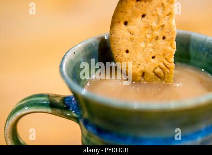 Biscuit digestif trempé dans une tasse de thé sur une pause Banque D'Images