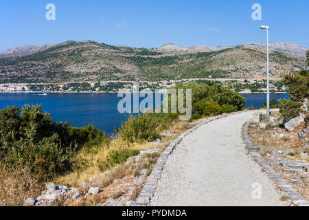 Côte de la mer Adriatique en Croatie, montagnes côtières et chemin de gravier le long de la rive, Dalmatie du sud de la région. Banque D'Images