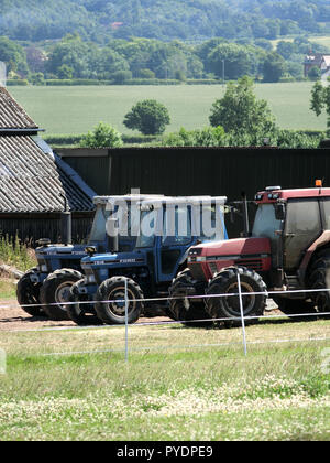 Case International 5150 & 7610 Ford Tracteurs sur une ferme, Staffordshire, England, UK en Juin Banque D'Images