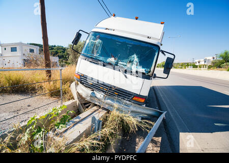 L'avant du camion en panne qui a frappé la barrière s'est écrasé sur la route, pare-brise cassé, journée ensoleillée Banque D'Images