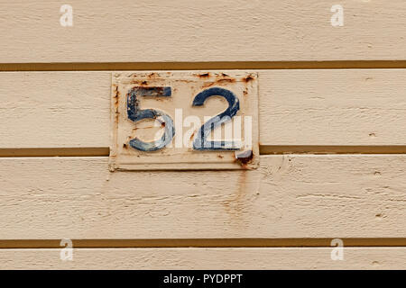 Numéro de maison cinquante-deux 52 en métal pressé patiné rouillé peint en bleu et crème en Suède Banque D'Images