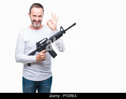 L'âge moyen des cadres supérieurs de l'homme criminel holding gun arme sur fond isolé ok faire signer avec les doigts, symbole excellent Banque D'Images