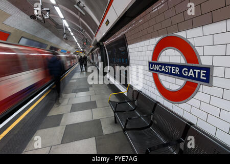 London Underground sign avec train en mouvement et les gens à la station de Lancaster Gate LONDRES - Mars 07, 2015 : London Underground sign avec train en mouvement et Banque D'Images