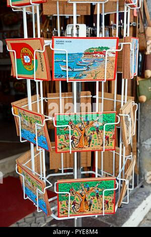 Le liège portugais traditionnels cartes postales sur un rack à l'extérieur d'une boutique dans la vieille ville, Tavira, Algarve, Portugal, Europe. Banque D'Images