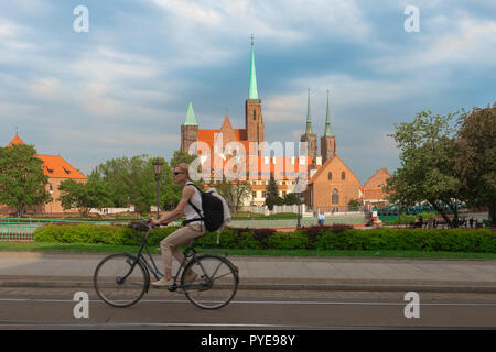 Wroclaw, une femme depuis l'horizon de cycles Tumski Island avec les clochers de l'église Sainte Croix (à gauche) et de la cathédrale St Jean le Baptiste (à droite),Pologne. Banque D'Images