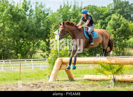 Saint Cyr du Doret, France - le 29 juillet 2016 : Woman riding horse plus obstacle à l'émission cross country event Banque D'Images