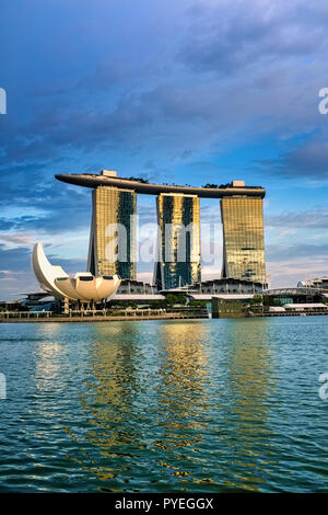 Le Marina Bay Sands Hotel à Marina Bay, Singapour, avec le Musée ArtScience à sa partie inférieure gauche, vu de l'autre côté de la baie en fin d'après-midi la lumière Banque D'Images