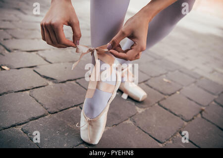 Cropped shot of young ballerina pointe de liage sur chaussure street Banque D'Images