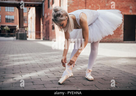 Les jeunes en jupe tutu ballerine blanche pointe de liage sur chaussure street Banque D'Images